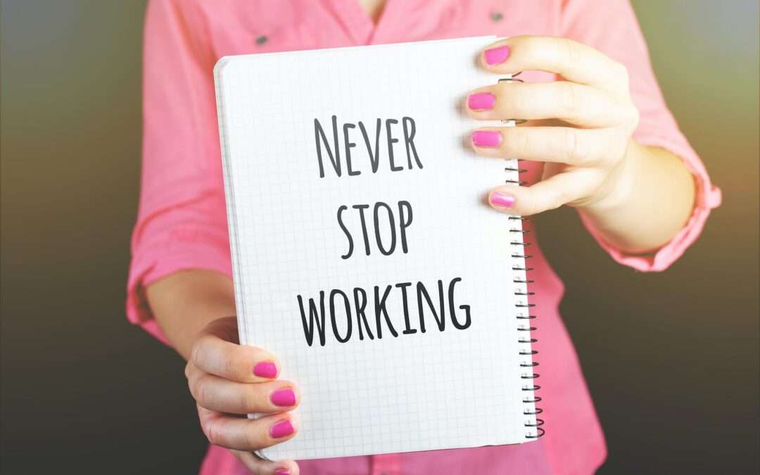woman holding never stop working print notebook